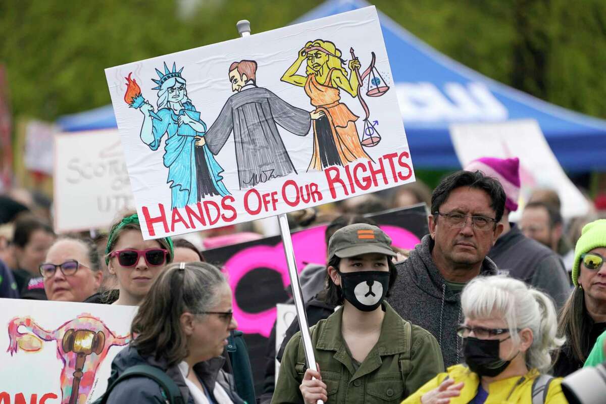 A person holds a sign that reads "Hands Off Our Rights" during a protest and rally for abortion rights, Saturday, May 14, 2022, in Seattle. Demonstrators are rallying from coast to coast in the face of an anticipated Supreme Court decision that could overturn women’s right to an abortion.