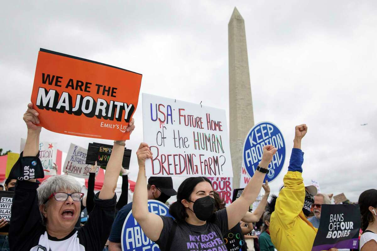 Abortion rights demonstrators raise their fists and signs during a rally, Saturday, May 14, 2022, on the National Mall in Washington. Demonstrators are rallying from coast to coast in the face of an anticipated Supreme Court decision that could overturn women’s right to an abortion.