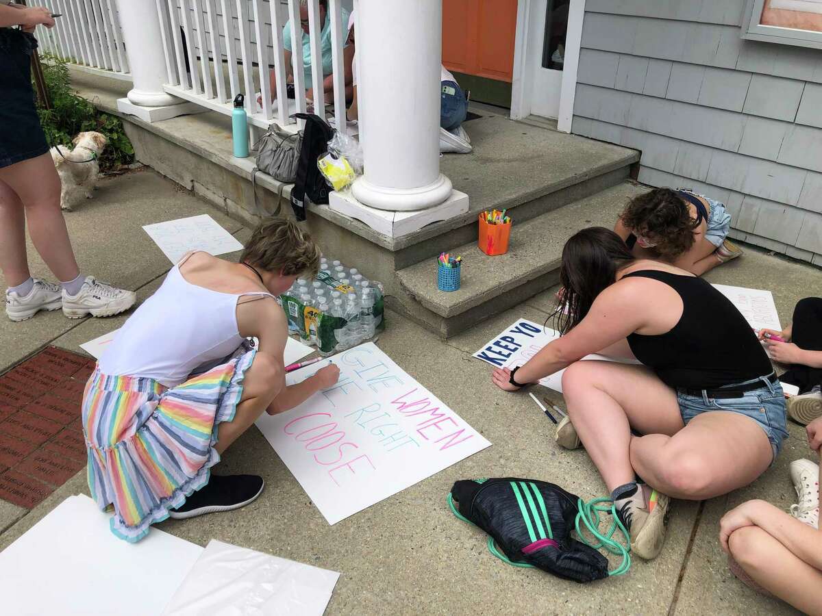 Attendees make posters for the Saturday march in support of abortion rights in Darien.