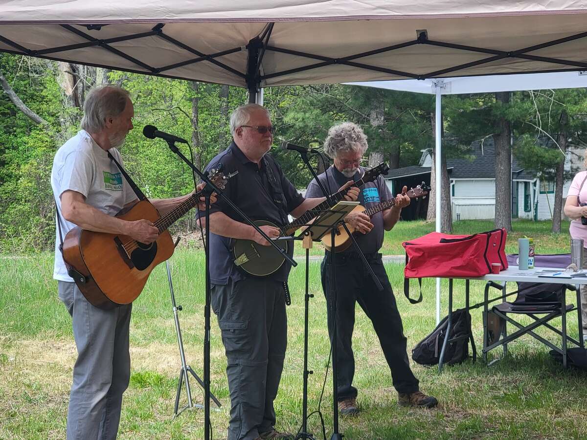 Ingemar Johansson, president of HARP, Paul Schulte, board member, and Bill Ward, trustee for the village of Honor, sing at the groundbreaking ceremony for the Platte River Park on Saturday. 
