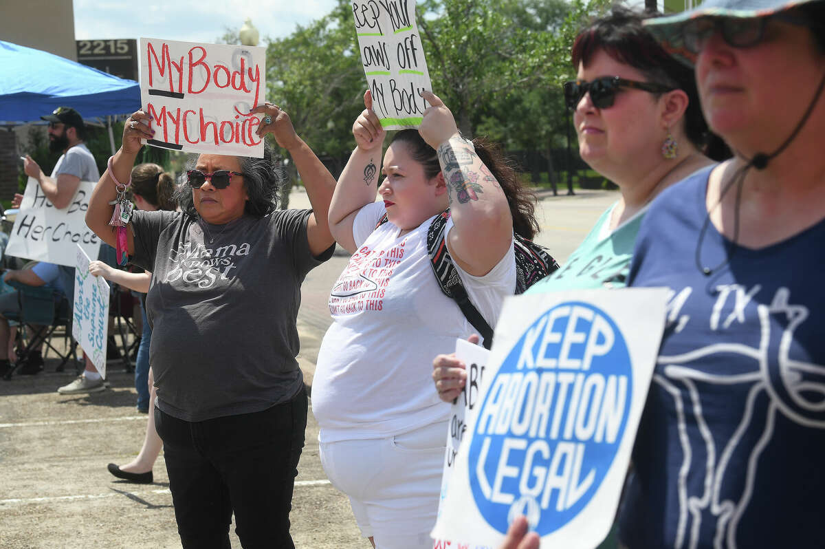 Ralliers, including Mary Pacella (far left) and her daughter Anna Pacella, hold up their signs during a rally for women's and abortion rights at the Jefferson County Democratic headquarters Saturday. Photo made Saturday, May 14, 2022. Kim Brent/The Enterprise