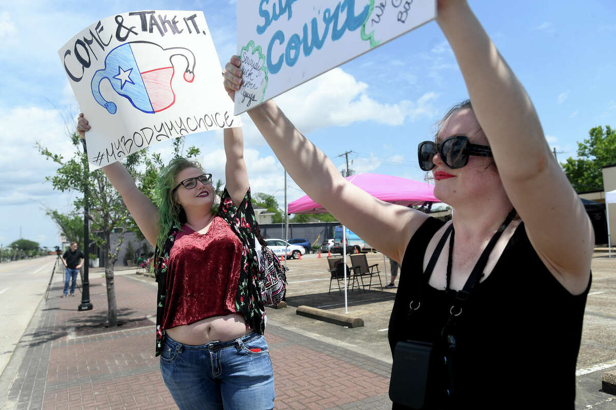 Organizers Merideth Alcaraz (left) and Lauren Woods hold their signs up on Calder Avenue during a rally for women's and abortion rights at the Jefferson County Democratic headquarters Saturday. Photo made Saturday, May 14, 2022. Kim Brent/The Enterprise