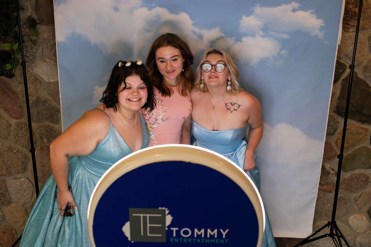 From left, Ashley Perry, Kayla Soper and Morgan Gould take a photo together as students from Midland and Dow high schools attend their joint prom Saturday, May 14, 2022 at the Great Hall Banquet & Convention Center in Midland.