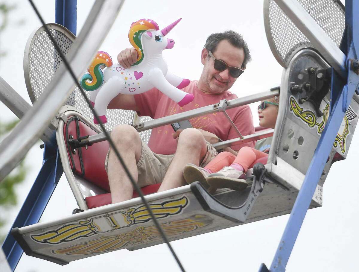 Dan Minar and son Charlie Minar, 3, of Milford, enjoy a ride on the Ferris wheel at the annual St. Mary’s School Carnival on Gulf Street in Milford, Conn. on Saturday, May 14, 2022.