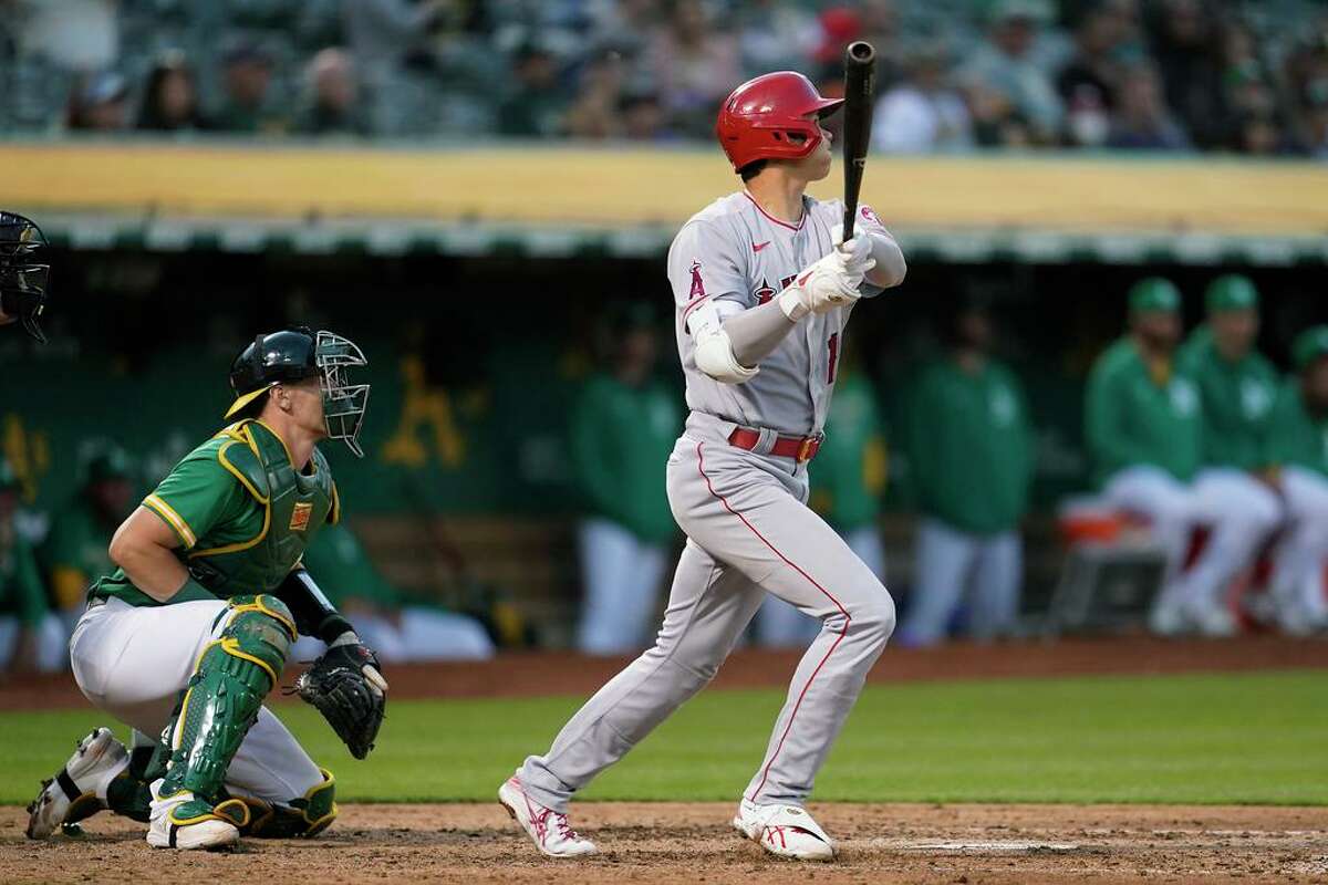 Los Angeles Angels' Shohei Ohtani watches his two-run home run in front of Oakland Athletics catcher Sean Murphy during the fifth inning of the second baseball game of a doubleheader in Oakland, Calif., Saturday, May 14, 2022. It is Ohtani's 100th homer in the majors. (AP Photo/Jeff Chiu)