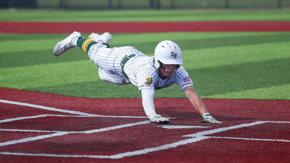 SANTA FE, TX MAY 14: Santa Fe Indians Kyeler Thompson (2) dives into home plate in the bottom of the second inning to score a run during the Region III-5A area playoffs- Game 2 high school baseball game between the Milby Buffaloes and Santa Fe Indians at Santa Fe High School in Santa Fe, Texas.
