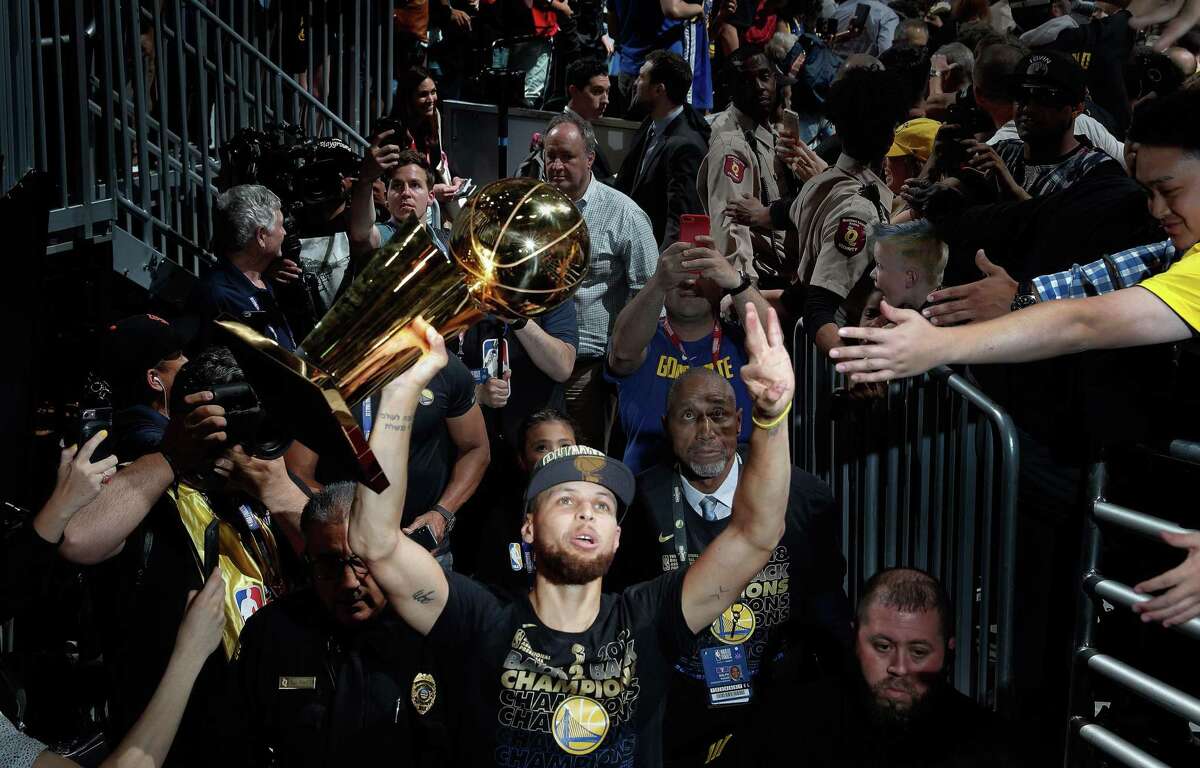 Stephen Curry walks off the arena floor with the Larry O’Brien Trophy after the Warriors defeated the Cavaliers in Game 4 of the NBA Finals at Quicken Loans Arena in Cleveland on June 8, 2018. It was the Warriors’ third championship in four years.