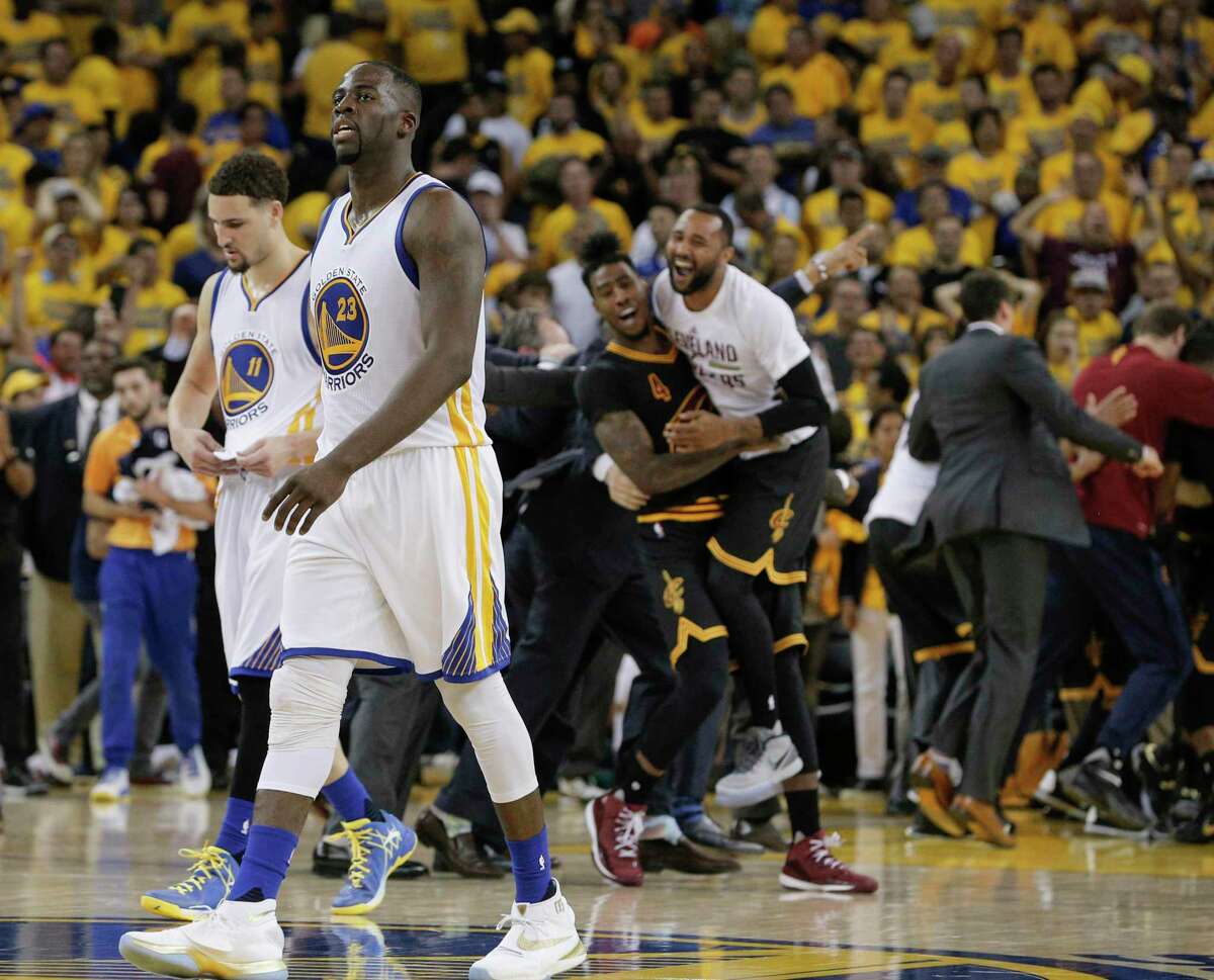 Klay Thompson and Draymond Green walk off the court as the Cleveland Cavaliers celebrate their victory over the Warriors in Game 7 of the NBA Finals on June 19, 2016, in Oakland.