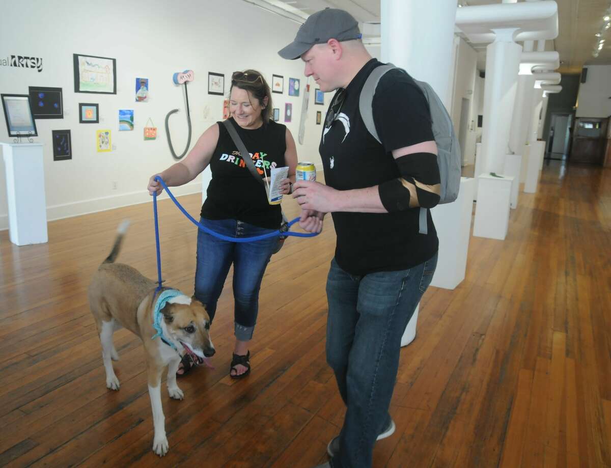 Scout accompanies owners Della and Keith Ragsdale of Granite City as they visit the Jacoby Arts Center during Saturday's Pup Crawl.  