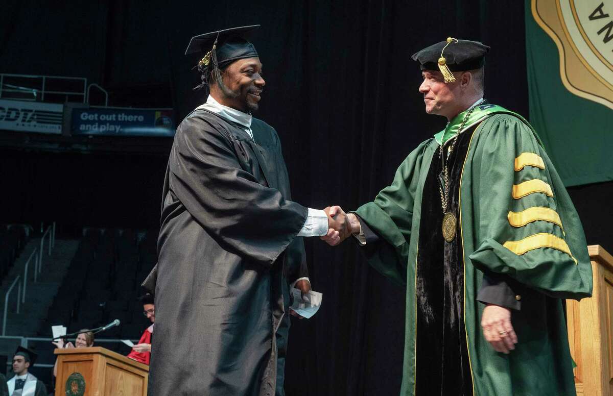 Former Siena basketball player Doremus Bennerman shakes hands with Siena President Christopher Gibson during the college's commencement exercises at the MVP Arena on Sunday, May 15, 2022, in Albany, N.Y. (Paul Buckowski/Times Union)