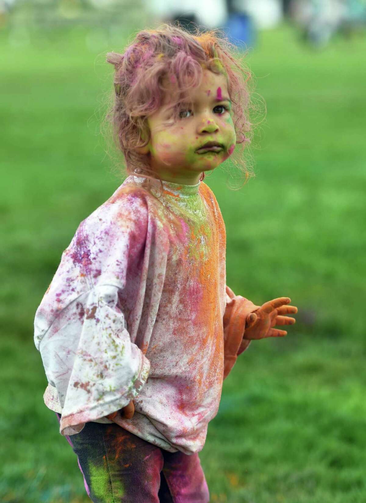 Nyla Ahlwalia, 22 months old, enjoys being covered in colored chalk dust the India Cultural Center of Greenwich's Holifest and Color Throw at Roger Sherman Baldwin Park in Greenwich, Conn., on Saturday May 14, 2022. Although the Color Throw is highlight of event, there were plenty of other activities like Indian food, arts and crafts, DJ Kunjun providing music, henna tattoos and an ice cream truck.