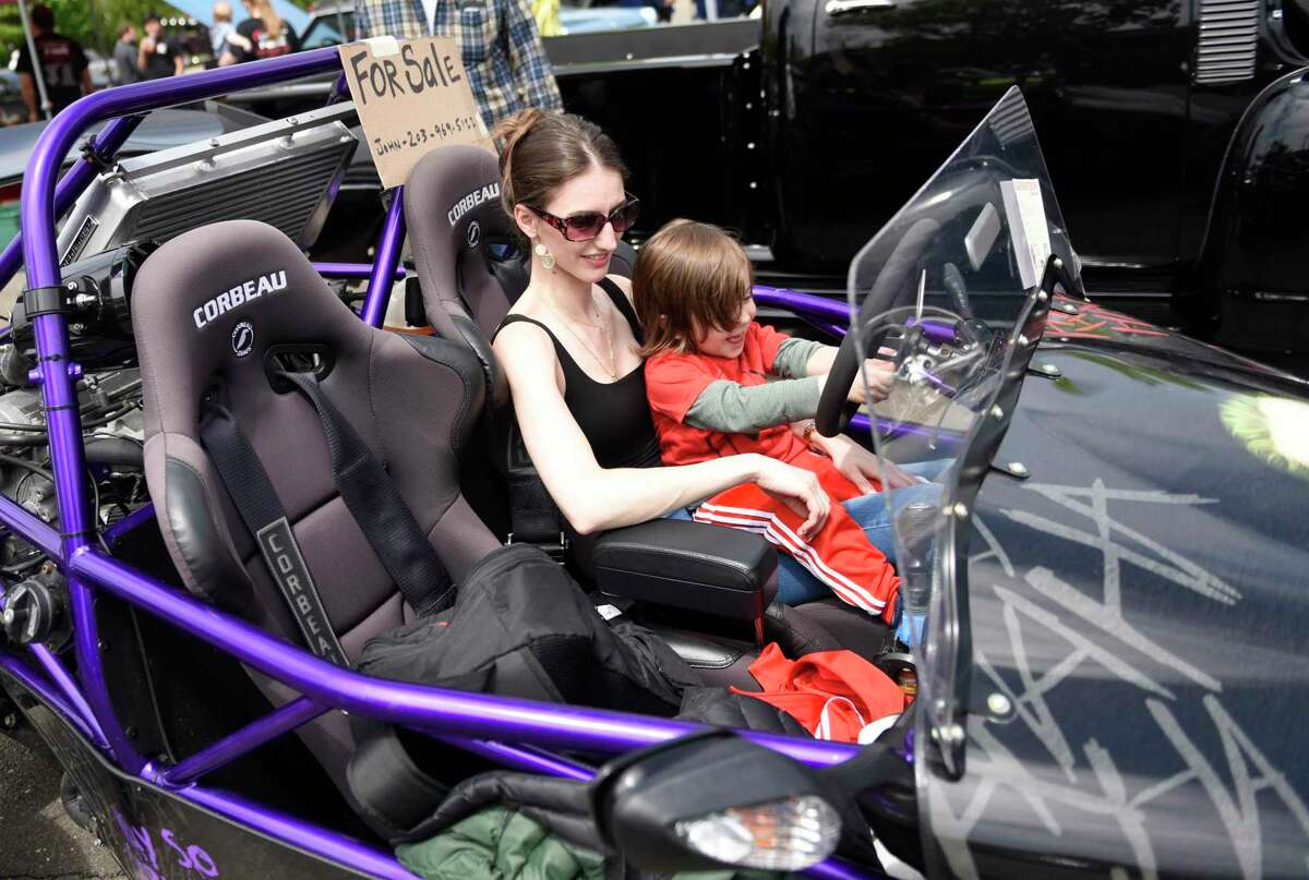 Stamford’s Frideriki Koletsos and Adrian, 4, sit inside John Duhani’s 2018 DF Goblin kit car on display at the J.M. Wright Tech Car Show at Scalzi Park in Stamford on Sunday. The show featured hundreds of classic cars, tuner cars, exotics, motorcycles, and more, along with a DJ, food and vendor booths.