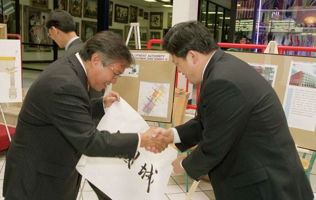 Houston City Councilmember Gordon Quan, left, receives a handwritten sign with the words "Chinatown" in Chinese characters made by Chinese Consul General Hu Yeshun during a press conference announcing a master plan to revitalize the city's original Chinatown, just east of downtown Houston, Thursday, June 5, 2003.