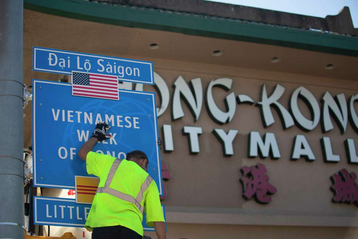Workers hanging a “Walk of Honor” sign honoring military leaders of the Army of the Republic of Vietnam Monday, Nov. 22, 2021, at corner of Bellaire Boulevard and Boone Road in Houston. International Management District will be hoisting "Walk of Honor" signs at five intersections in Asian Town, where many Vietnamese Americans reside, shop and do business.