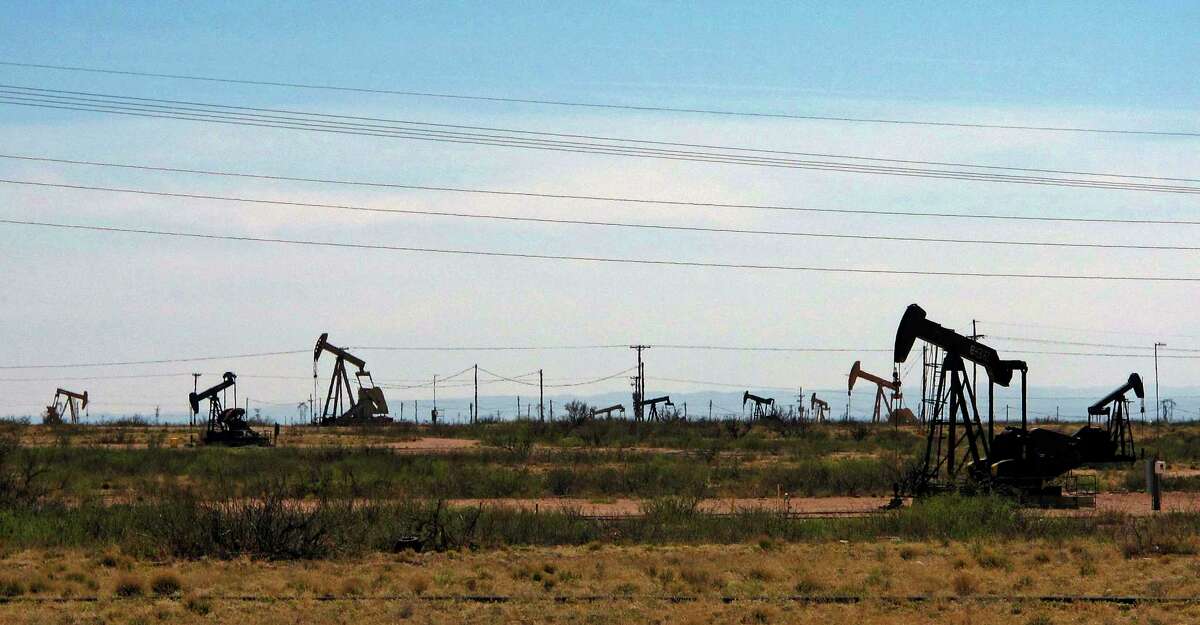 FILE - Oil rigs stand in the Loco Hills field along U.S. Highway 82 in Eddy County, near Artesia, N.M., one of the most active regions of the Permian Basin. Government budgets are booming in New Mexico. The reason behind the spending spree — oil. New Mexico is the No. 2 crude oil producer among U.S. states and the top recipient of U.S. disbursements for fossil fuel production on federal land. But a budget flush with petroleum cash has a side effect: It also puts the spotlight on how difficult it is for New Mexico and other states to turn their rhetoric on tackling climate change into reality.