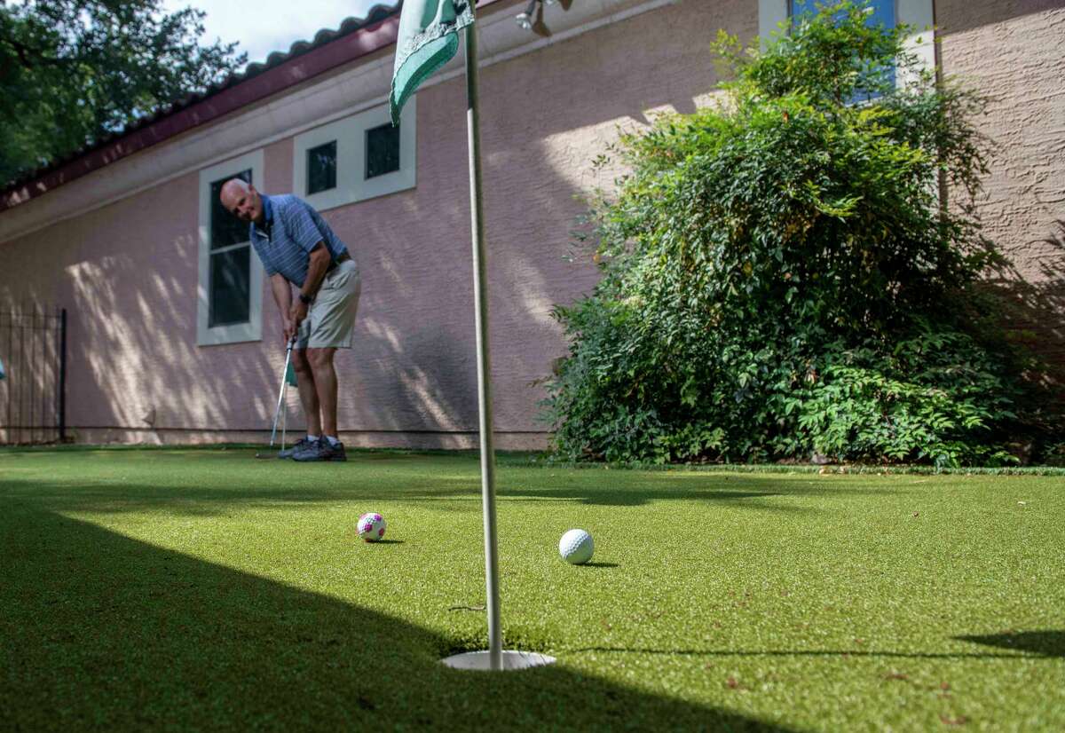 Roger Burg practices on the artificial turf putting green in the backyard of his Rogers Ranch Home. Burg and his wife Sharon O’Malley Burg installed the fake grass in their yard to to help save on water.