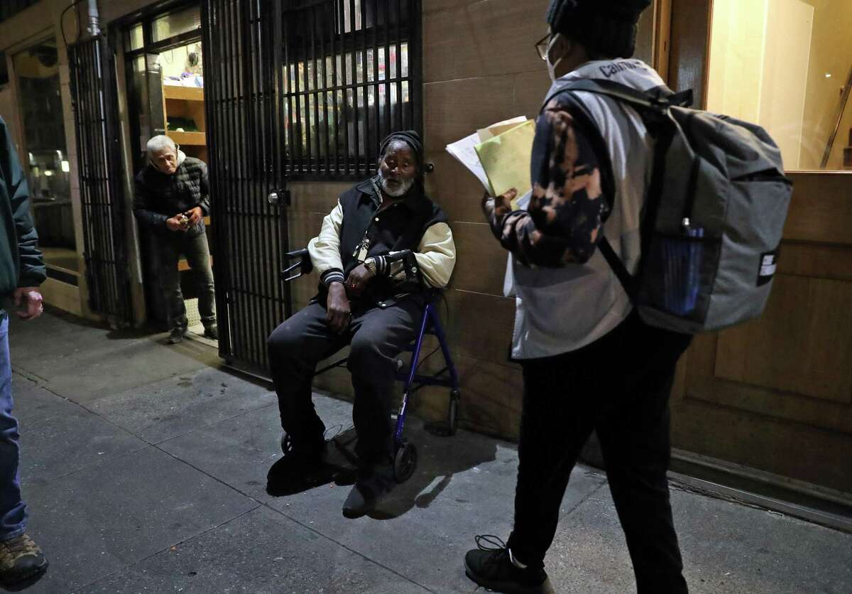 Tina O'Collins talks with Arthur, a homeless man, on Taylor Street during Point In Time one-night homeless count in San Francisco, Calif., on Wednesday, February 23, 2022.