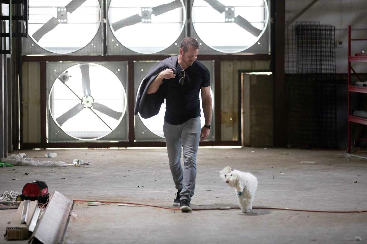 Caleb Ward and his dog Bubbie at his Geosyn Mining warehouse location northwest of Fort Worth, on Saturday, March 14, 2022. He plans to install solar panels to power his operation, envisioning his company leveraging the power of Bitcoin to help proliferate solar energy production. (Joyce Marshall/for the Chronicle)