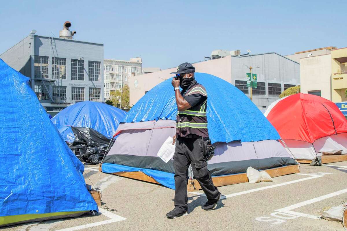 FILE-The Safe Sleeping Site at 33 Gough St., Tuesday, Sept. 21, 2021, in San Francisco, Calif. The city this year installed 70 cabins for homeless people to replace the 45 tents show here, just one intervention that left fewer people unsheltered in San Francisco.
