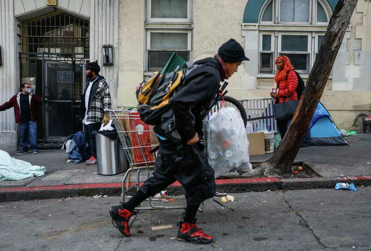 1月，无家可归的妇女萨米(右)在琼斯街上看着其他人经过的场景。