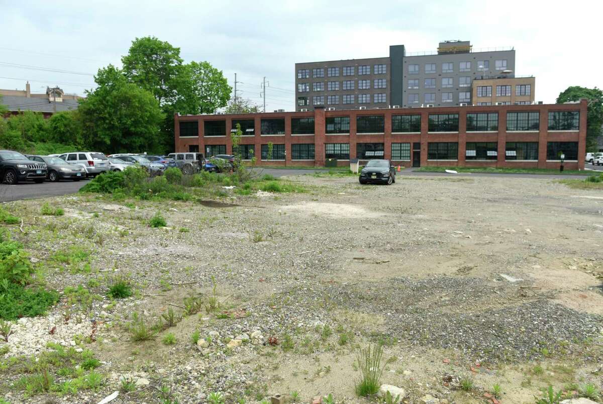 A lot adjacent to Platform SoNo Station and Shirt Factory Lofts is vacant in Norwalk, Conn. Monday, May 16, 2022. Connecticut Gov. Ned Lamont visited Monday to tour the space and speak about the vacant property adjacent that will receive $6 million to add 200 units of mixed-income housing, 10,000 square feet of commercial space, a public plaza, and 60 off-street parking spaces.