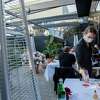 Rebekah Cook serves customers outside at Californios in San Francisco in 2021. Restaurant staff recently voted to put masks back on at work because of the recent COVID uptick.