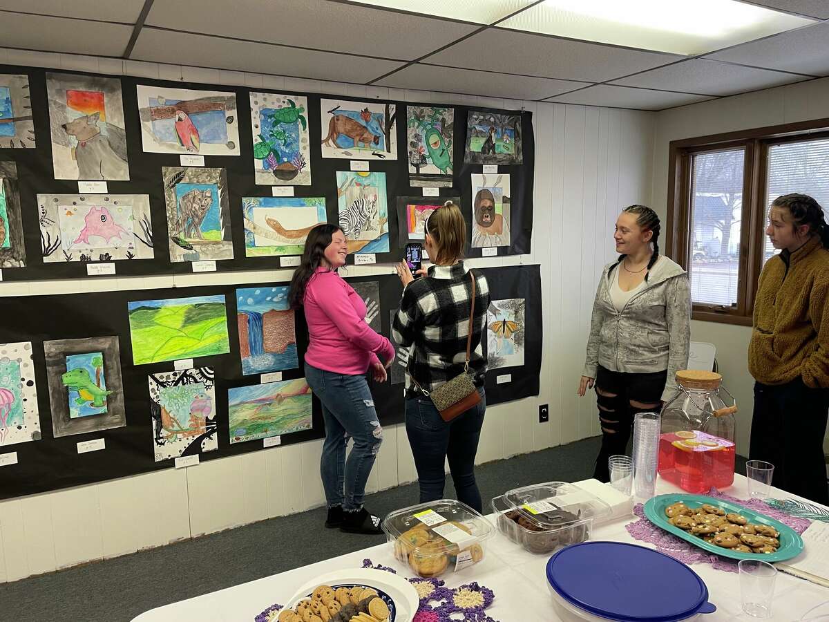 McKenzie Gruber (left), Mya Wilson and Iyana Sielski, Brethren Middle School students, stand by their work on April 30 during a reception at the Kaleva Art Gallery.