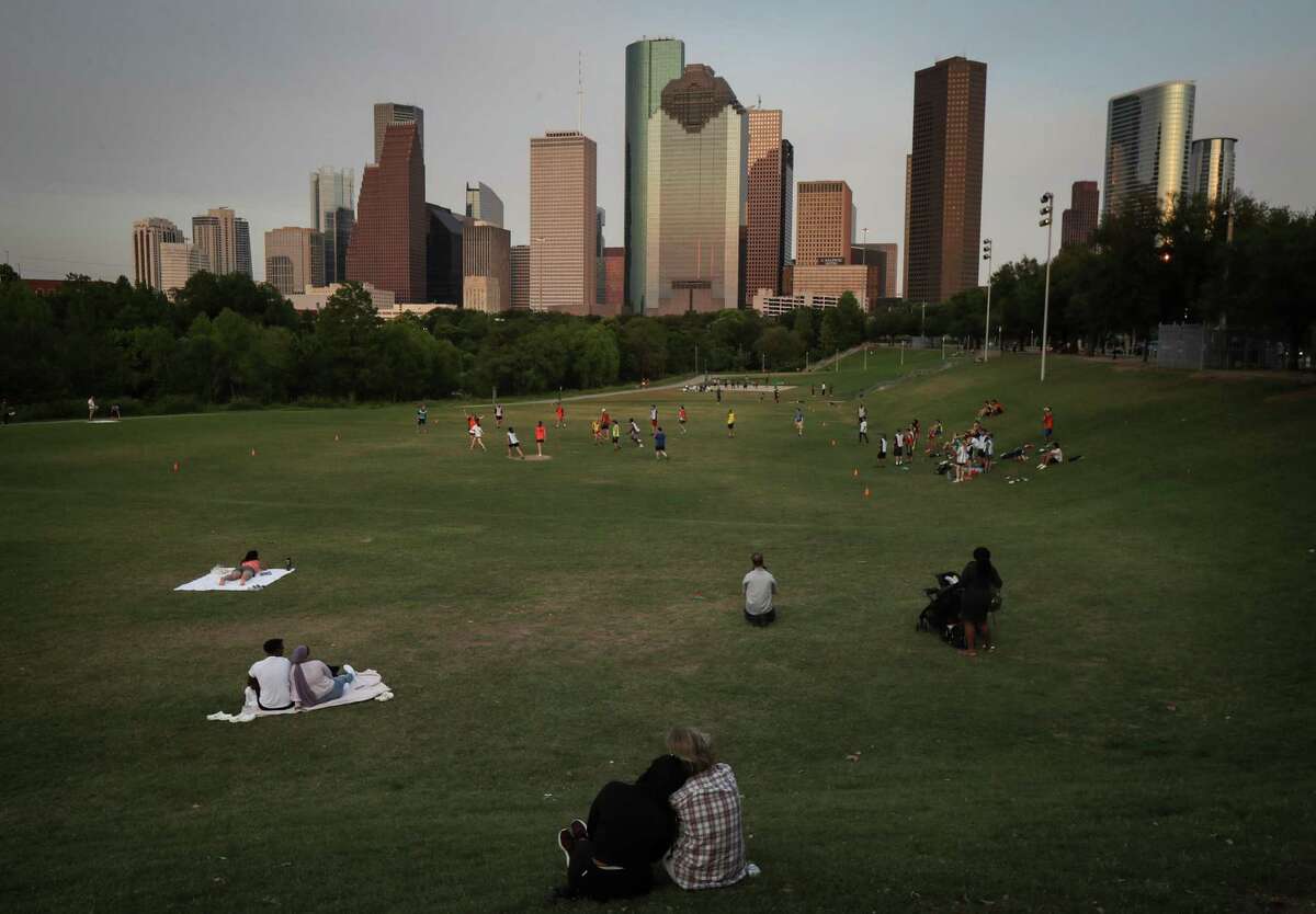 A couple watches the sun set Monday, May 16, 2022, at Eleanor Tinsley Park in Houston.
