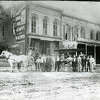The Gerber Building was a fixture on Main Street for more than a century. The estimated date for this photograph is the 1890s when the Palace Store occupied the building. The horse and surrey were transportation for the St. James Hotel located out of view, about a half block north of the Gerber Building. The musicians are unknown.