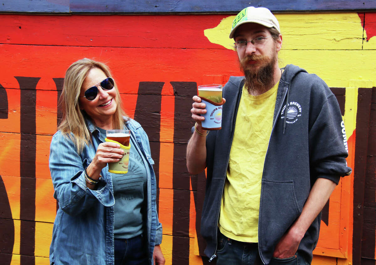 Thumb Brewery co-owner Lauren Formicola and brewer Nick Bowlby take a break in the Caseville brewery's patio area. Thumb Brewery is expanding its brewing capacity.