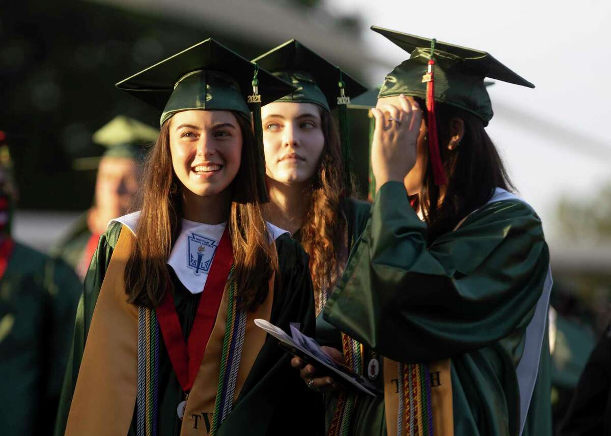 Lorren Kathryn Banker, left, shares a smile as she walks to the stage area during The Woodlands High School's graduation ceremony at the Cynthia Woods Mitchell Pavilion, Tuesday, May 25, 2021, in The Woodlands.
