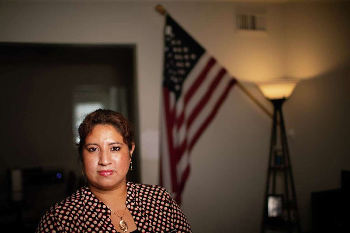 Latinos for Education 2021 fellow Monica Reyes, 40, and mother of an undocumented student, stands by a United States flag inside her home, Tuesday, May 17, 2022, in Houston.