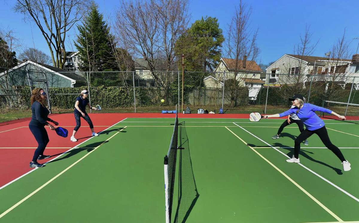 Seniors play pickleball on the tennis courts at Loughlin Avenue Park in Greenwich, Conn., on Friday March 18, 2022. Pickleball, a sport gaining in popularity in the town, has plenty of seniors seeking to support and protect proposed funding for it in the upcoming town budget.