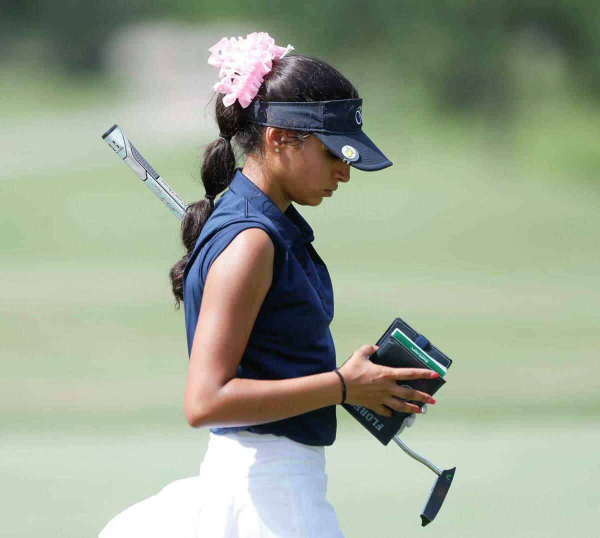 Bella Flores of Kingwood checks her course book on ninth green during the final round of the Class 6A UIL State Golf Championship at Legacy Hills Golf Club, Tuesday, May 17, 2022, in Georgetown.