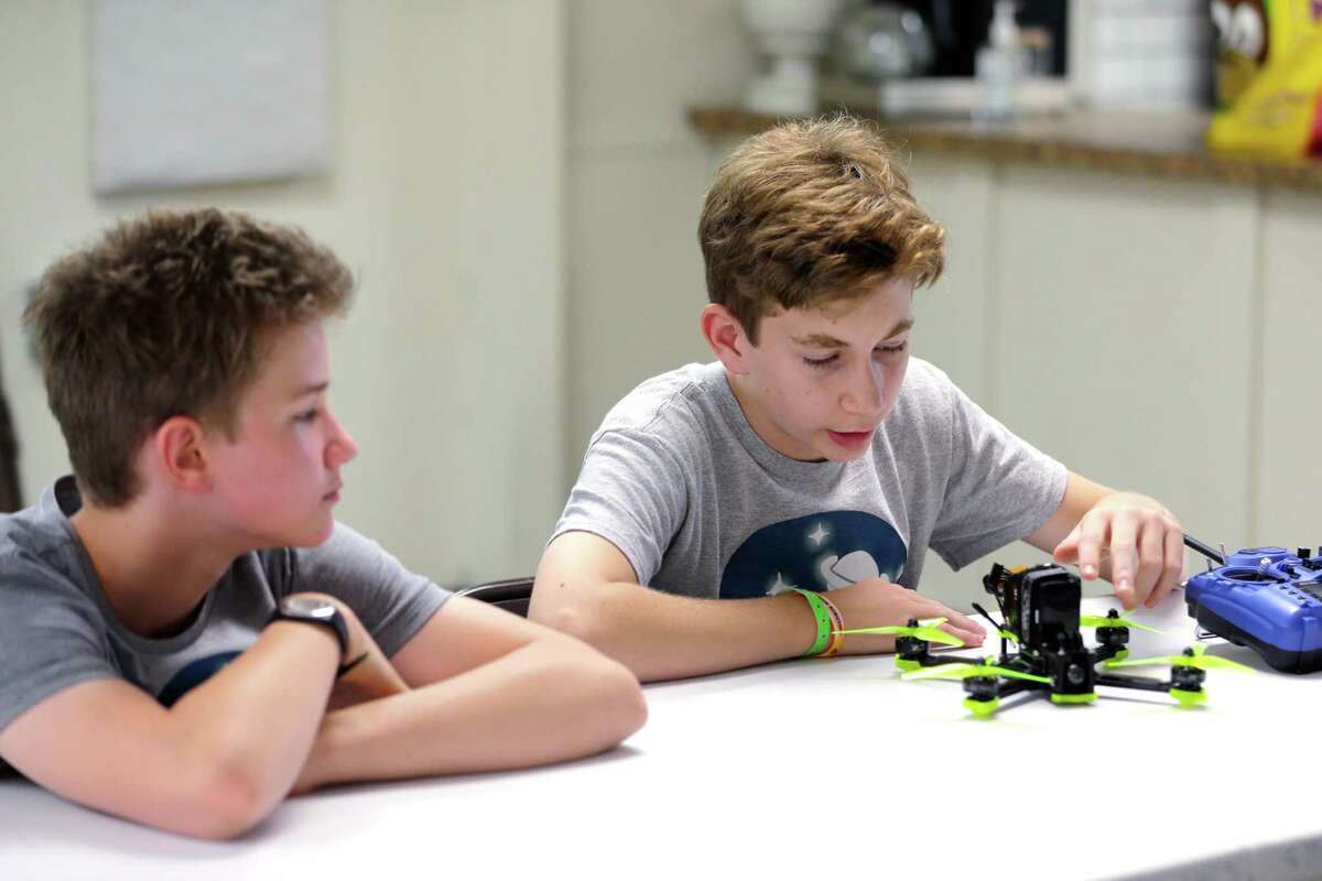 Scott Davidson, right, age 14, explains parts of the drone he is currently building to Jay Herz, left, age 12. They are both in the drone education program for students at the private All Nations Community School Tuesday, May 17, 2022 in Oak Ridge, TX.