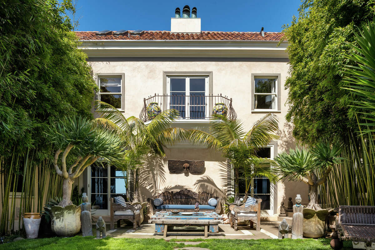 A tree-lined lawn and patio create a private courtyard on the property is south-facing.   