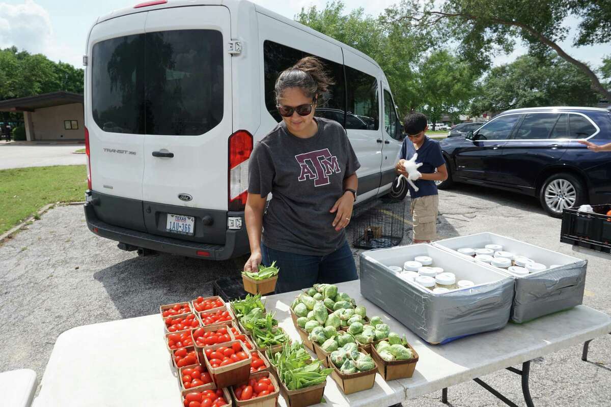 Ashley Barker of PEAS Farm sells fresh vegetables on Thursday, May 5 at the Westchase District Farmers Market in Houston.