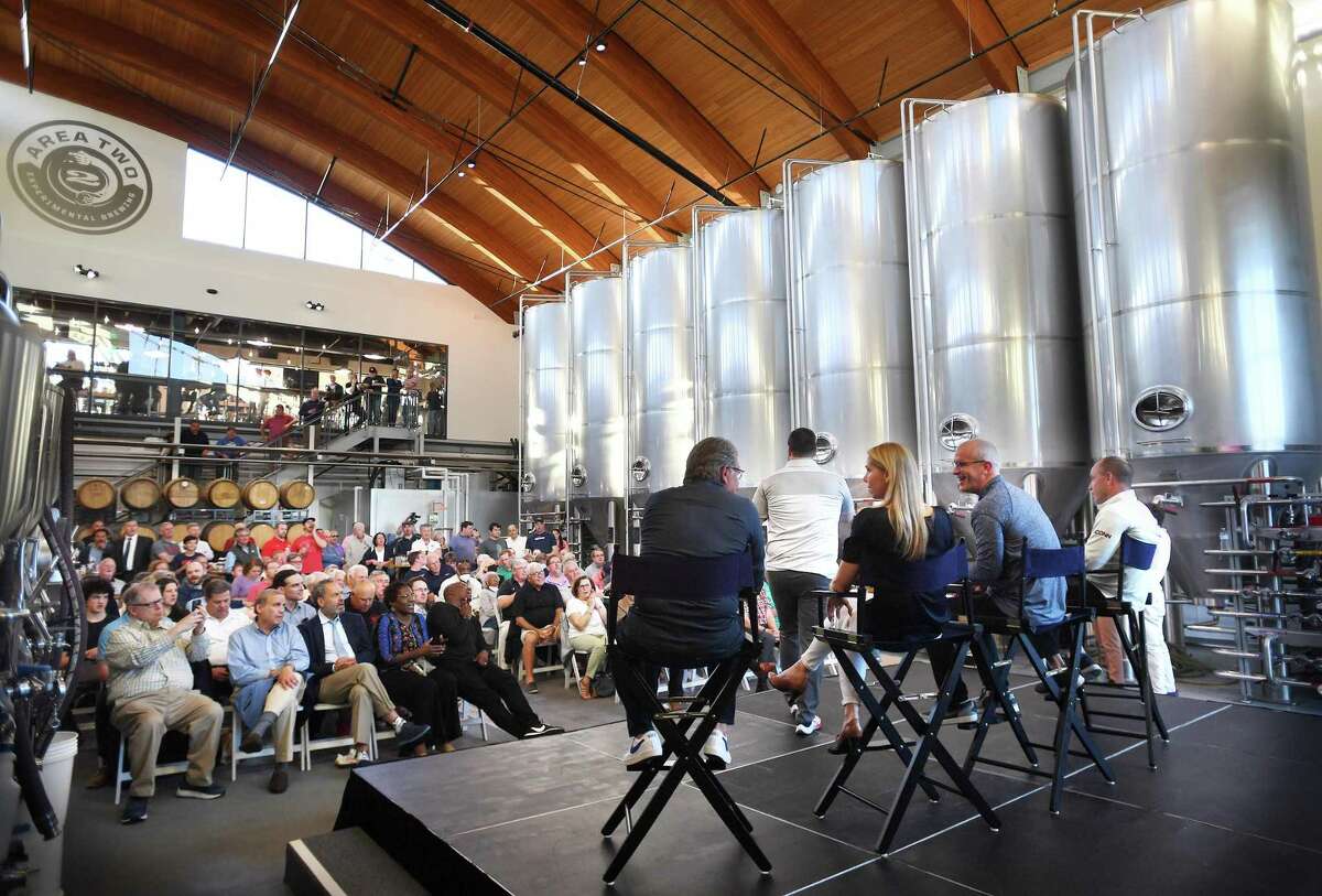 UConn coaches field questions from fans during the UConn Road Show at Two Roads Area 2 brewery in Stratford, Conn. on Saturday, May 14, 2022. From left are women's basketball Coach Geno Auriemma, women's soccer Coach Margaret Rodriguez, men's basketball coach Dan Hurley, and hockey Coach Mike Cavanaugh.