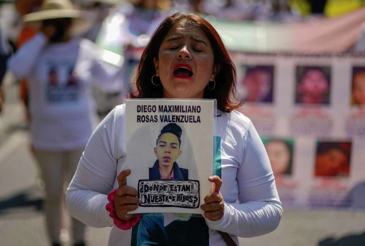 A protester holds an image of a youth with the name Diego Maximiliano Rosas Valenzuela and the question in Spanish "Where are our children?" during an annual Mother's Day march by the families of missing people to demand the government help locate them in Mexico City, Tuesday, May 10, 2022. (AP Photo/Eduardo Verdugo)