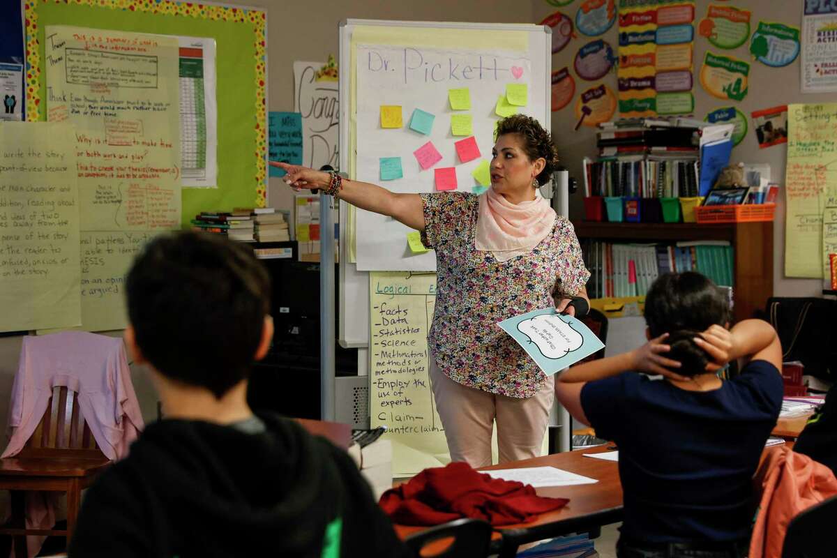 Anita Pickett, who received a raise under the state's Teacher Incentive Allotment program, works with students at Somerset Junior High School. The raise came as low pay and overwork are pushing teachers to leave the profession.