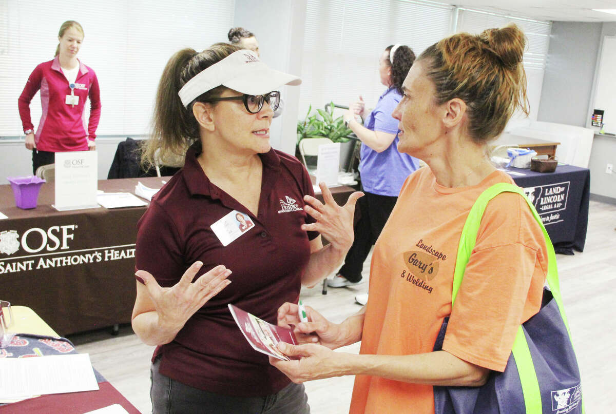 Mary Jo Smith, left, of the Hospice of Southern Illinois Inc., talks to Teresa Bunting, of East Alton at the Senior Services Plus Spring Health Fair Wednesday in Alton. The fair featured dozens of booths ranging from information to COVID booster shots.