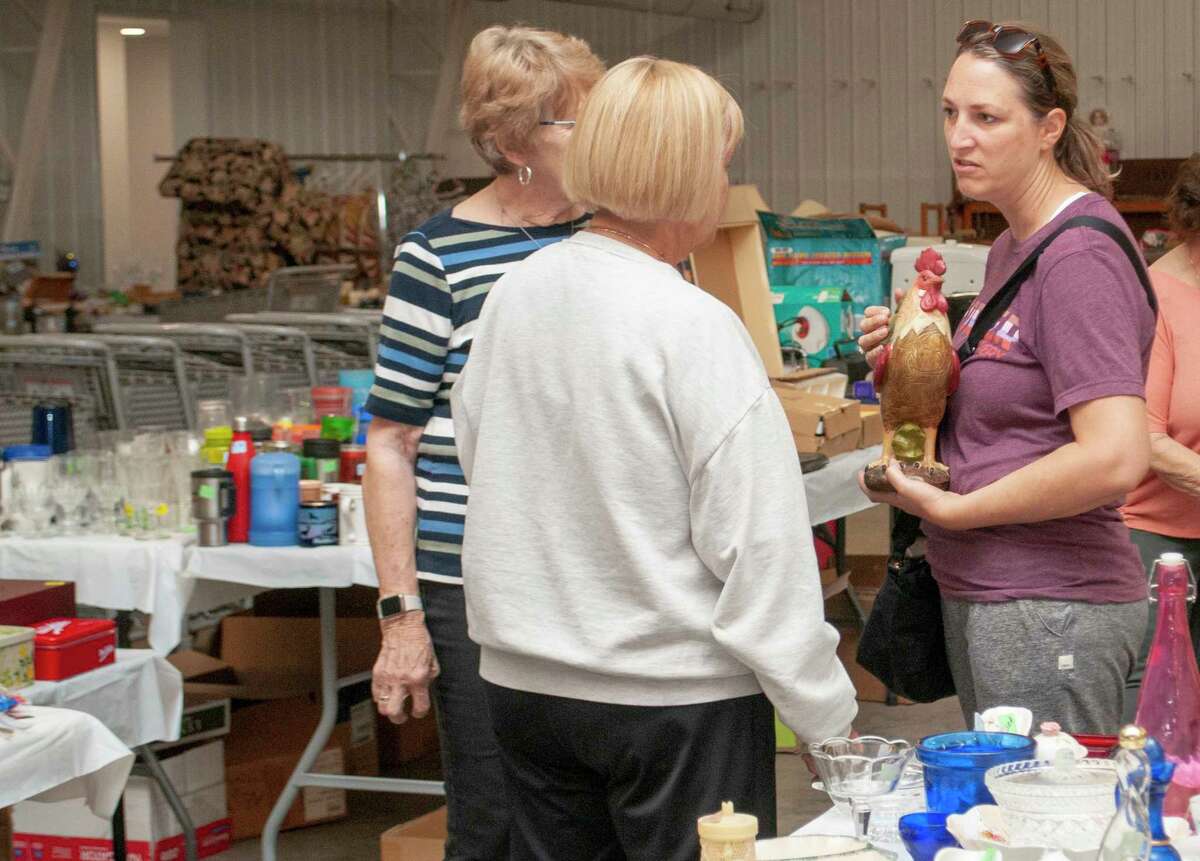 Linda Curtis (left) Charlotte Denight and Carrie Cole take a break from setting up The Salvation Army Women's Auxiliary Flea Esta sale.