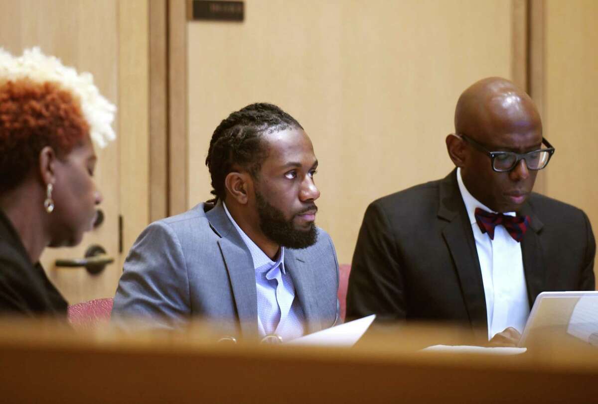 Deshawn Hayes, center, attends the first day of trial in a joint murder case at Connecticut Superior Court in Stamford, Conn. Monday, Nov. 1, 2021. Trial began Monday for Deshawn Hayes and Jhonel Telemin-Valerio, who are accused of fatally shooting Maxine Gooden, a 43-year-old mother of five, in 2015.