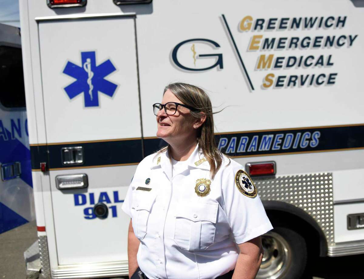 GEMS Executive Director Tracy Scheitinger chats beside a GEMS ambulance parked outside The Cos Cobber in the Cos Cob section of Greenwich, Conn. Wednesday, May 18, 2022. Greenwich EMS held its annual fundraiser at The Cos Cobber, with an ambulance parked out front and a portion of all sales donated to GEMS.