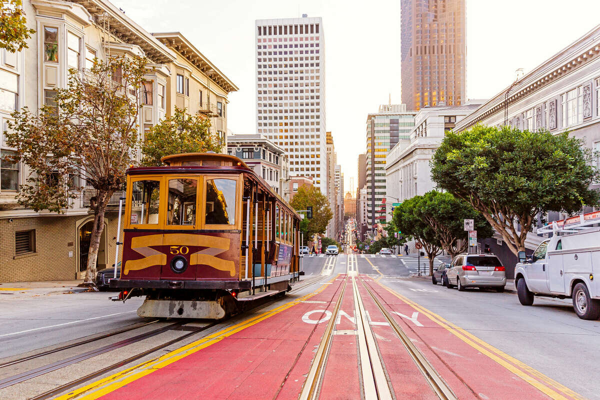 A historic cable car climbs a hill in San Francisco.