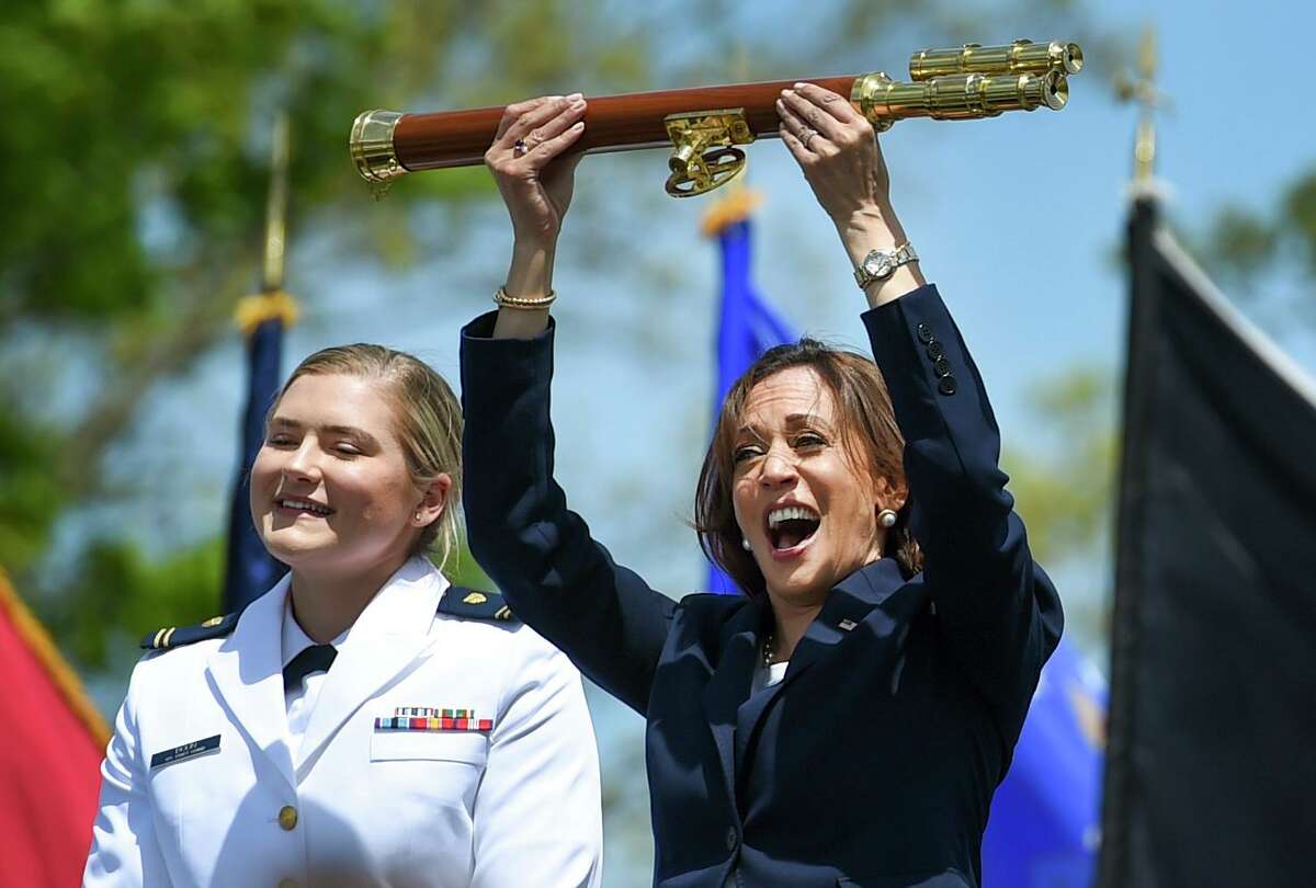 Vice President Kamala Harris lifts the school scepter at the conclusion of the U.S. Coast Guard Academy's 141st Commencement Exercises Wednesday in New London. At left is Carolyn Ziegler, the last cadet of the 250 to graduate.