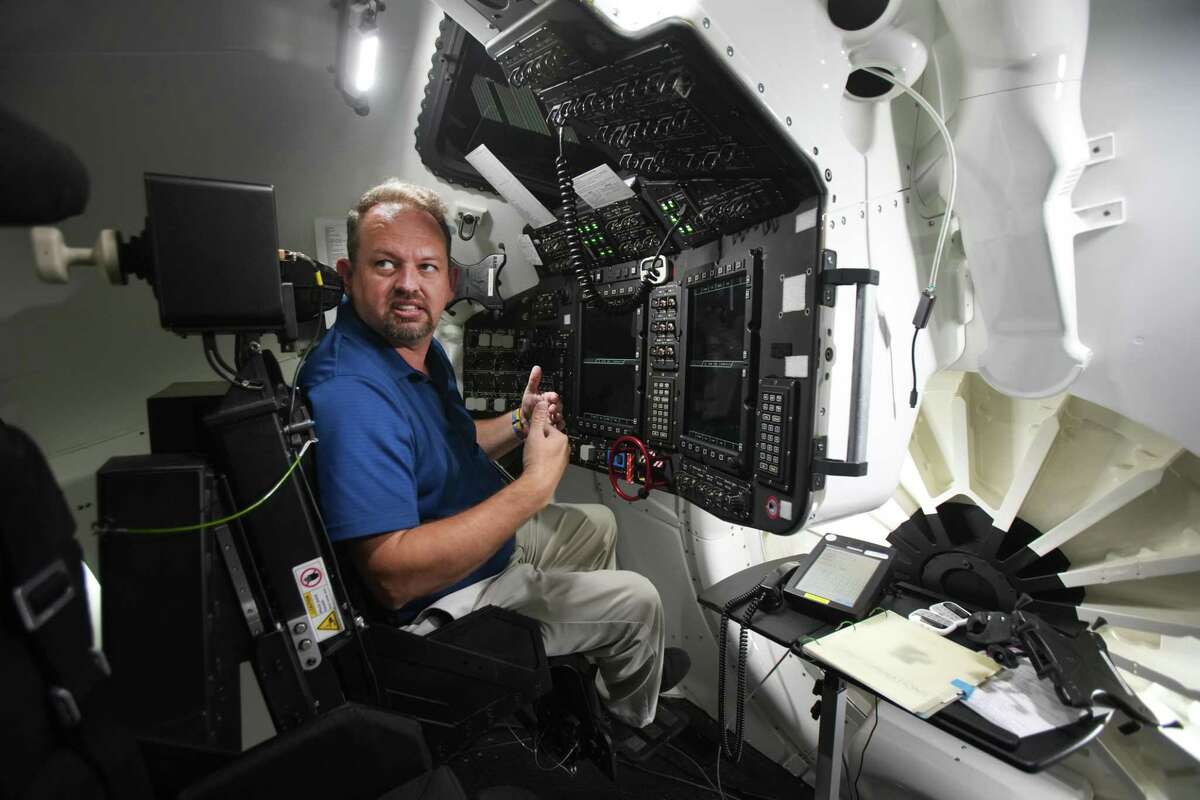 Steven Siceloff, of Boeing, demonstrates a simulator for the Boeing CST-100 Starliner spacecraft at NASA’s Johnson Space Center Tuesday, May 17, 2022 in Houston. This spacecraft is expected to dock with the International Space Station this week as part of an uncrewed test flight.