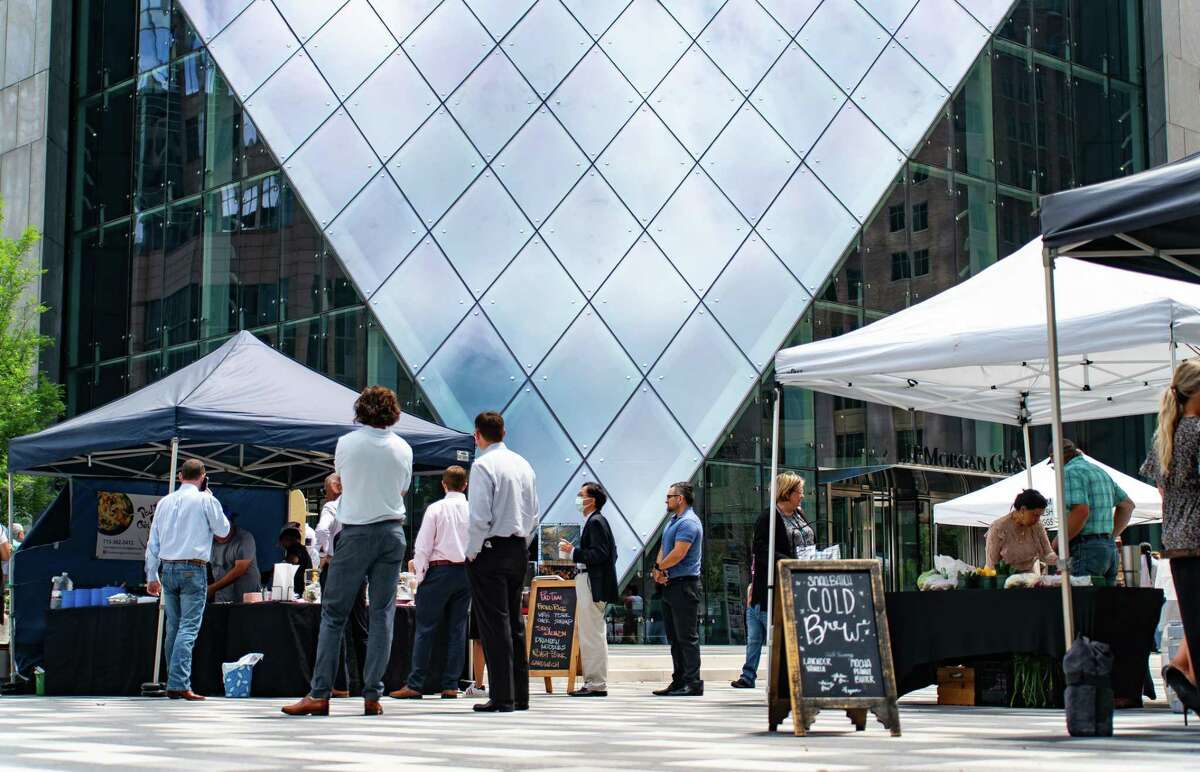 People wait in line at food stalls and food trucks outside the JPMorgan Chase Tower during lunchtime, Wednesday, May 4, 2022, in downtown Houston.