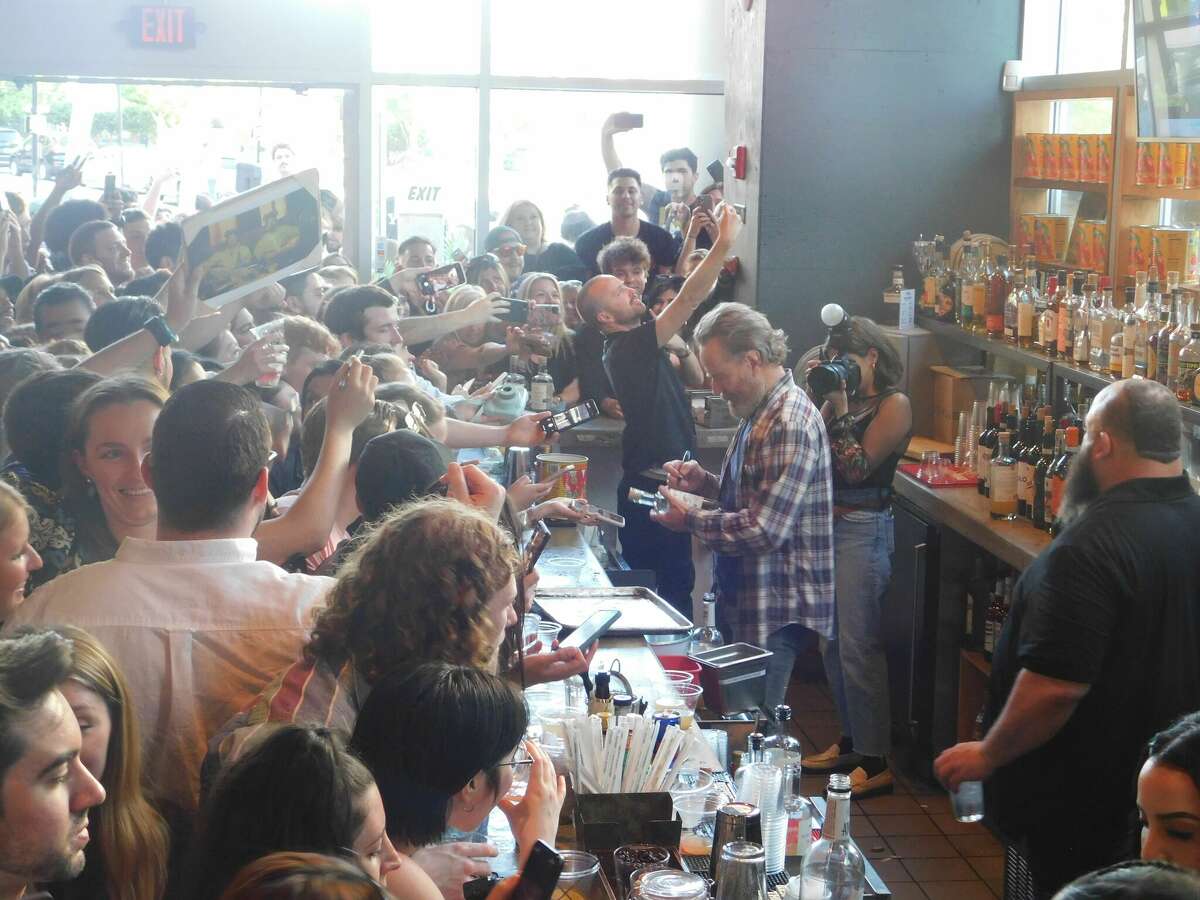 "Breaking Bad" stars Aaron Paul and Bryan Cranston sign bottles of Dos Hombres and take selfies with their fans at Fortina in Stamford on May 18. 
