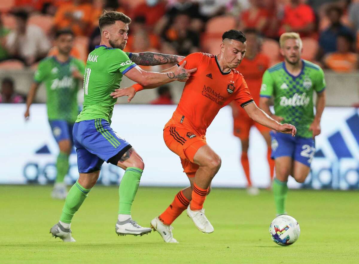Seattle Sounders midfielder Albert Rusnák (11) tries to slow down Houston Dynamo FC forward Sebastián Ferreira (9) during the first half of an MLS match at PNC Stadium on Wednesday, May 18, 2022, in Houston.